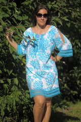 Fototapeta premium woman in a blue dress and sunglasses in the summer in the park