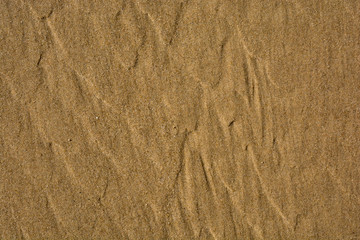 Golden sand on the beach close-up texture for background or wallpaper