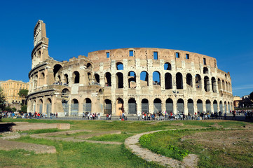 Fototapeta na wymiar View of the exterior of the Colosseum, Coliseum, in Rome with green meadow in front on a spring day
