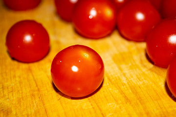 Small red cherry tomatoes on a wooden Board. Close up.