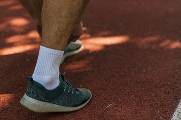 Fototapeta na wymiar Close-up photo of male running shoes on a race track in the park