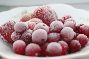 Frozen cherries and strawberries on a white plate