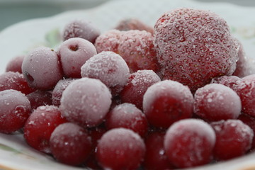 Frozen cherries and strawberries on a white plate