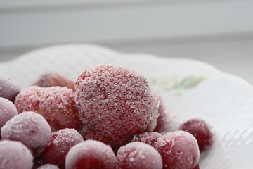 Frozen cherries and strawberries on a white plate