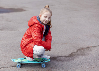 Smiling teen girl with green skateboard in sport park