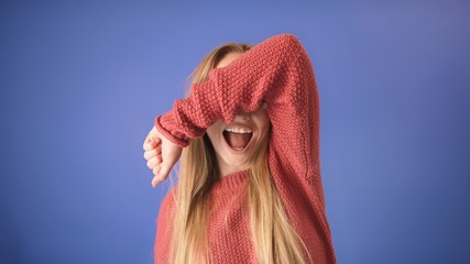 BeautifuBeautiful blond girl laughing out loud and covering her eyes with the hand. Isolated on...