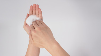 Hands washing gesture with foaming hand soap on white background.  Top view.