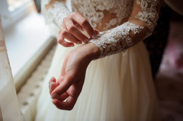 brides hands that arranges her dress