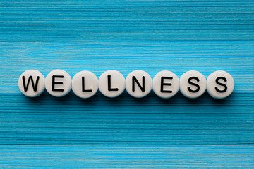 Wellness text on a blue wooden table - obrazy, fototapety, plakaty