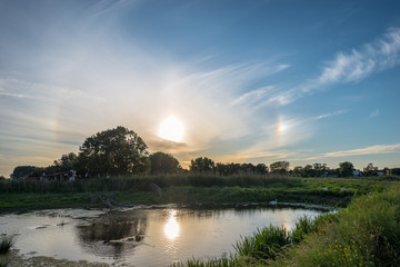 22 degree circular halo with sundogs (parhelia) to the left and right of the sun. Meteorological optical phenomena.