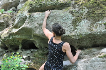 One young active woman climbing on rock during bouldering training outdoor sport leisure activity in bavaria