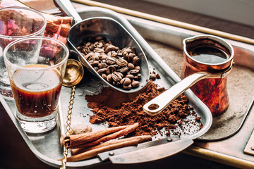 A glass of freshly brewed coffee ET, scoop with coffee beans. Making coffee in the sand. Arabica.