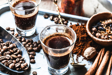 A glass of freshly brewed coffee on the eastern, coffee beans, close-up. Making coffee in the sand....