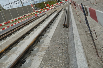 Fototapeta na wymiar new tram line rails installed in the ground on a concrete base and some spare rails beside it. A scene from a civil engineering construction site enhancing transport. 