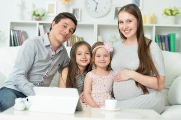 Portrait of happy pregnant woman with husband and daughters