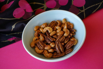 Bowl of sweet, salty, roasted and spiced nuts, pecan and cashew mix.