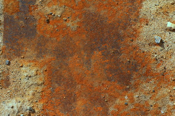 Iron leaf covered with strong deep red and brown rust with sand and stones. The texture of corrosion, wear and destruction. Place for text and background for design.