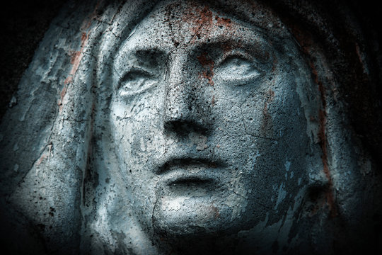 Close up ancient statue with cracks: Virgin Mary. Horizontal image.