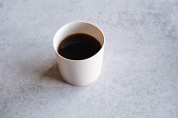Obraz na płótnie Canvas Cup of black coffee in a handmade white ceramics mug, white marble background