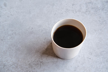 Cup of black coffee in a handmade white ceramics mug, white marble background