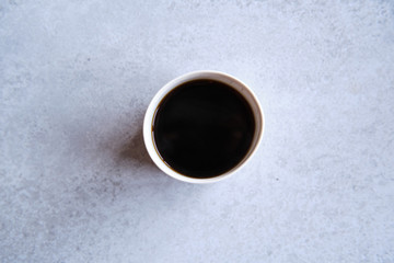 Cup of black coffee in a handmade white ceramics mug, white marble background