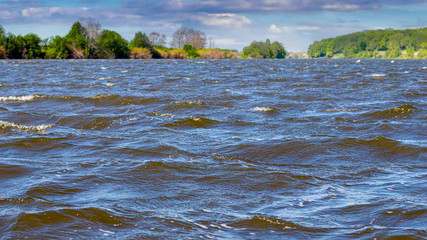 River with dark water and waves in windy weather