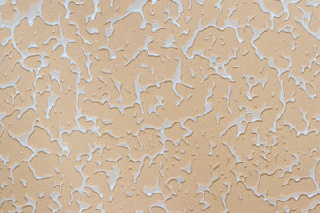 Texture of decorative plaster with white elements on an orange background