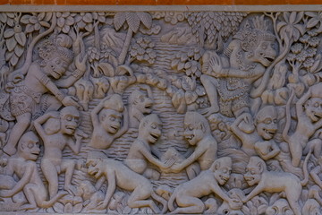 High reliefs of demons and monster fighting with monkeys in Pura Dalem Penunggekan in Bangli village, near Ubud, Island of Bali, Indonesia 