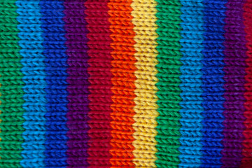 A knitted wool fabric in the colors of the rainbow. Fun background. Vertical strip