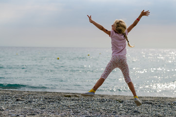 Obraz premium cute little girl jumping up in sunset time