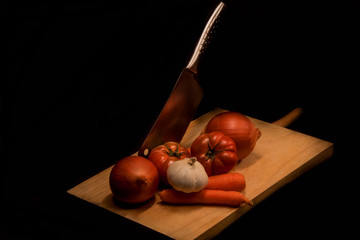 View of vegetables on slicing board with knife