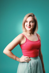 Portrait of blonde caucasian girl in pink t-shirt isolated on green background
