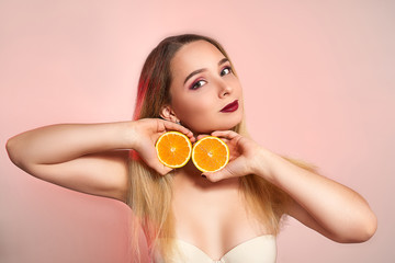 Beautiful girl with orange, isolated on studio background. Cosmetics, food, beauty fashion concept, space for text
