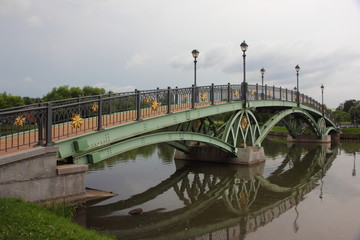 Moscow / Russia – 07 16 2019: Empty beautiful large green bridge in perspective close up in Tsaritsyno Park Museum on summer day, historical landmark