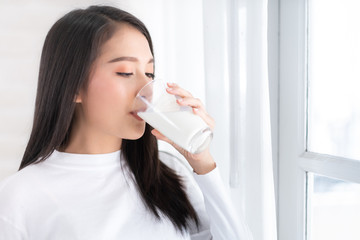 Young beauty Asian woman drink milk and smile