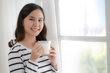 Young beauty Asian woman drink milk and smile