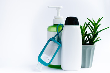 Disinfection product in white bottle standing next to Aloe Vera hand gel and aloe plant, isolated on white background. Hand skincare and protection during 