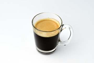Black coffee, intense roasted coffee, Robusta, Froth caused by coffee machine. In clear glass with a single side handle. Hot drinks beverage that is bitter good for health. Isolated white background.