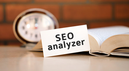 Seo analyzer - business concept text with a clock and an open book