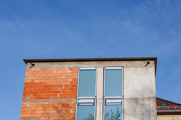 brick wall with windows against blue sky for copy space. Real estate under construction
