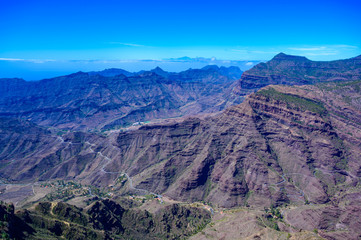 Fototapeta na wymiar Hiking in Mountain Scenery of Gran Canaria Island - Mountain Teide of Tenerife Island in the background - beautiful landscape scenery - travel destination in Spain