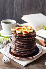 Chocolate pancakes, decorated with chocolate syrup and bananas