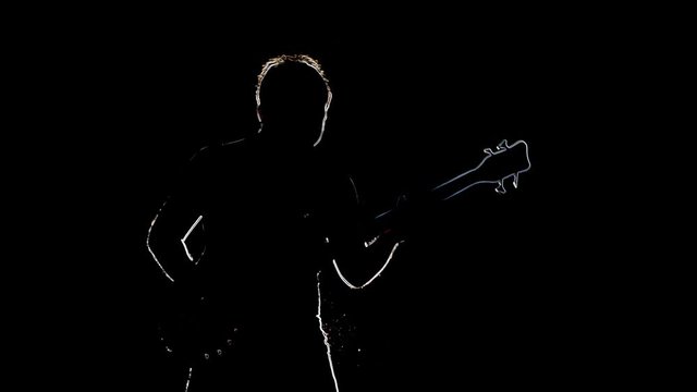 Outline sketch of man musician with bass guitar. Silhouettet isolated on a black background