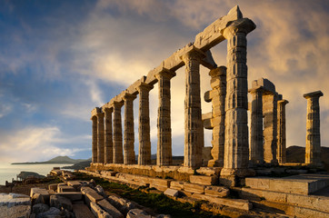 Temple of Poseidon at Cape Sounion, Attica / Greece. One of the Twelve Olympian Gods in ancient Greek religion and myth. He was god of the Sea, other waters and of earthquakes. Sunset with cloudy sky
