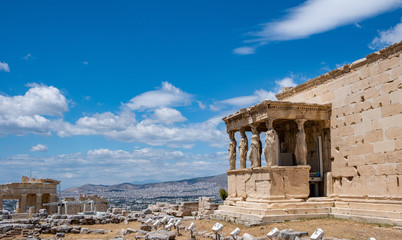 Fototapeta premium Athens, Greece. Erechtheion with Cariatides Porch on Acropolis hill, blue sky background