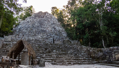 Tall Mayan pyramid made of precisely stacked stones from the middle of the tropical forest in Coba, Mexico.