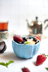 Mini-pancakes, Tiny pancakes, trendy food.
Fritters with fruit: blackcurrant, strawberry, mint. Breakfast with tea