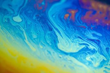 Fototapeta na wymiar Abstract background blue-yellow iridescent waves. Soap bubble texture