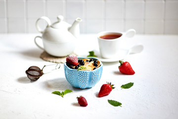 Mini-pancakes, Tiny pancakes, trendy food.
Fritters with fruit: blackcurrant, strawberry, mint. Breakfast with tea