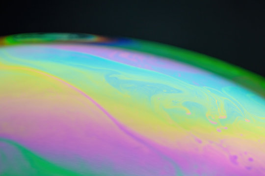 Abstract wave background shimmering on the surface of a sphere. Soap bubble texture © Alex